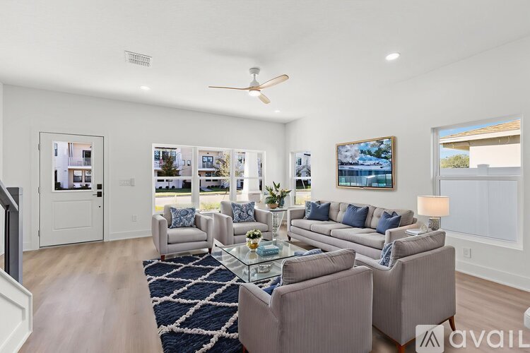 A living room with a couch, chairs, and a rug.