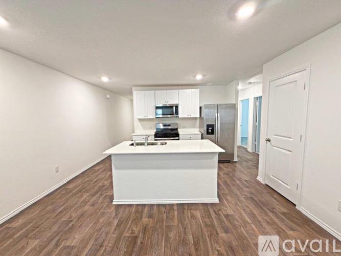 A kitchen with white cabinets and a white island with a countertop.
