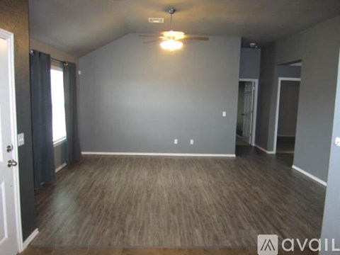 A room with a wooden floor and a ceiling fan.