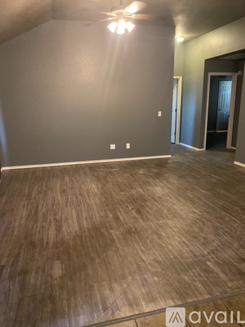 A room with wooden flooring and a ceiling fan.