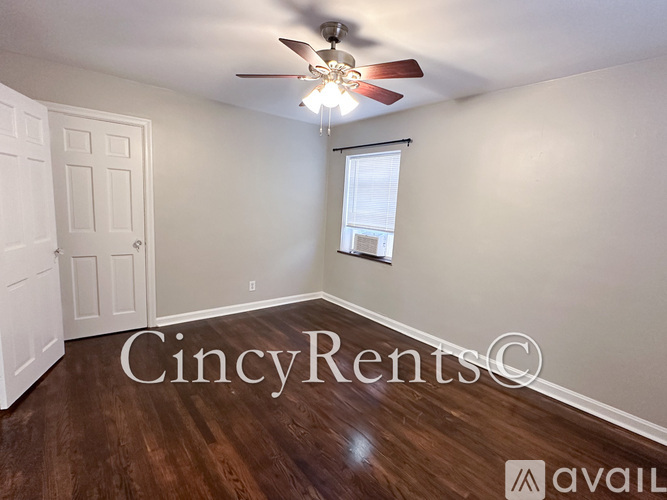 A room with a ceiling fan and wooden flooring.
