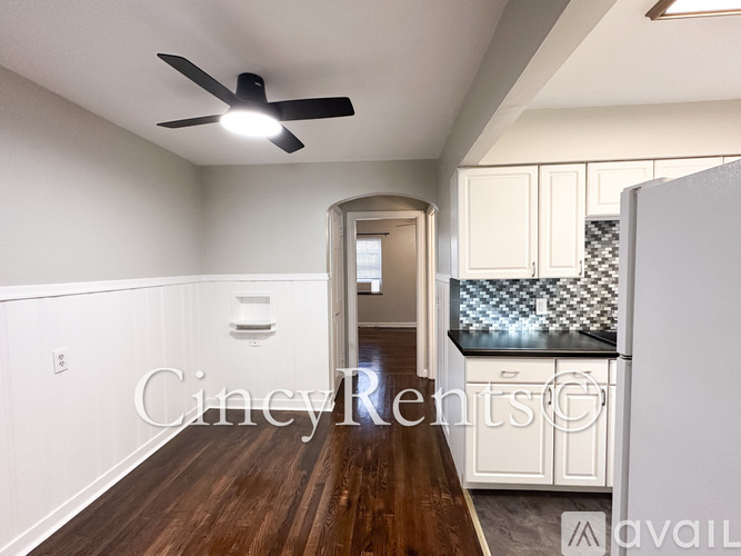 A room with a ceiling fan and wooden flooring.
