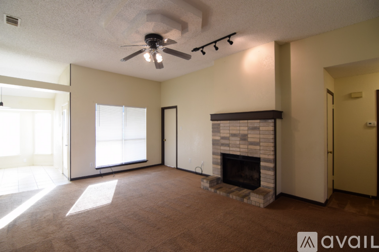 A living room with a fireplace and a ceiling fan.