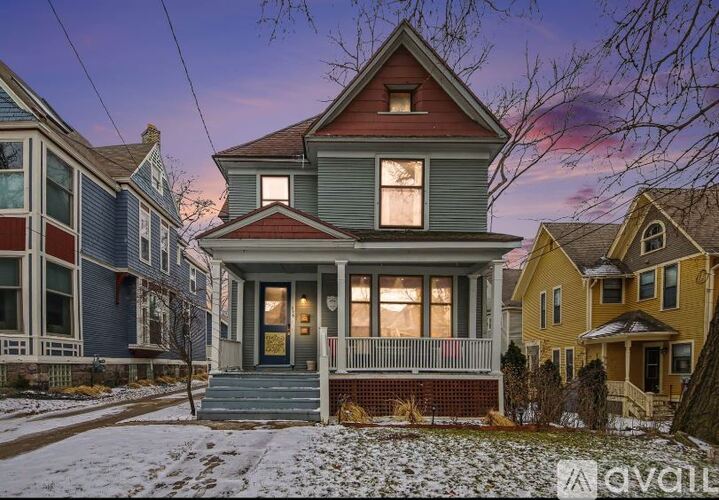 A house with a front porch and a snow-covered ground.