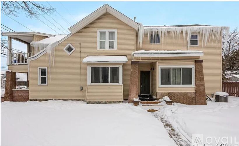 A house with a snow-covered roof and driveway.