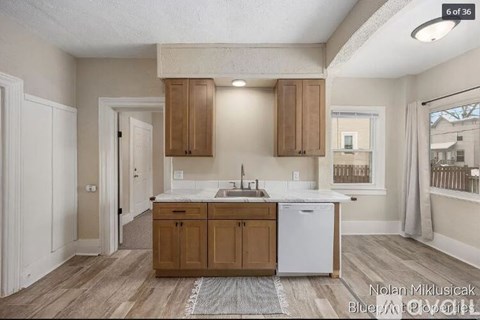 A kitchen with wooden cabinets and a white dishwasher.