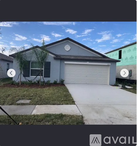 A house with a grey roof and a white garage door.