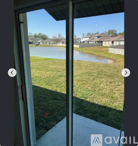 A view from a window looking out to a grassy area and a body of water.