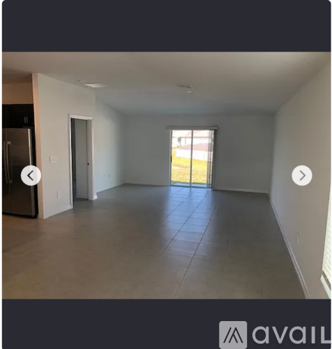 A spacious empty room with a door leading outside.
