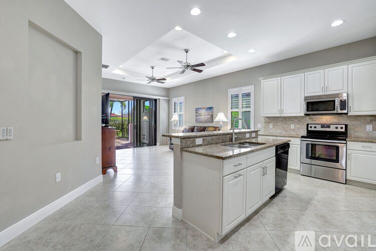 A modern kitchen with white cabinets and a large island.
