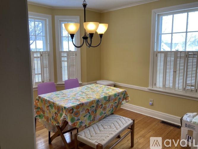 A dining room with a floral tablecloth and a chandelier.