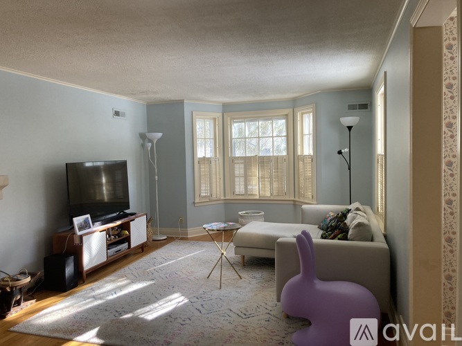 A living room with a television, a chair, and a table.