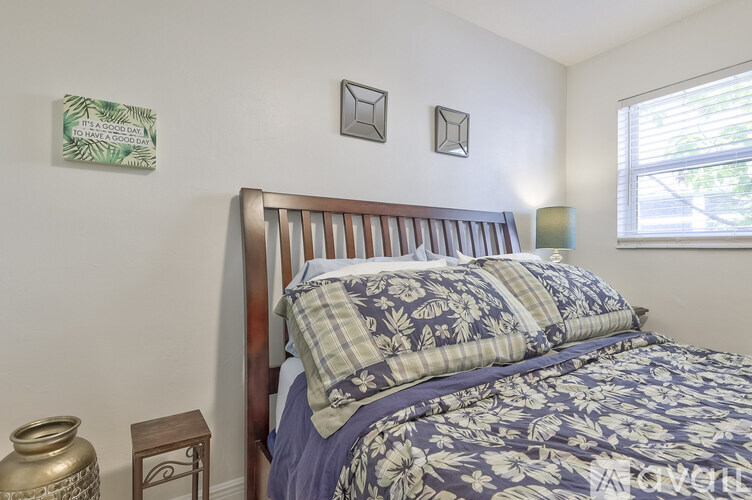 A bedroom with a bed and a small table.