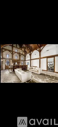 A spacious room with wooden beams and a large couch.