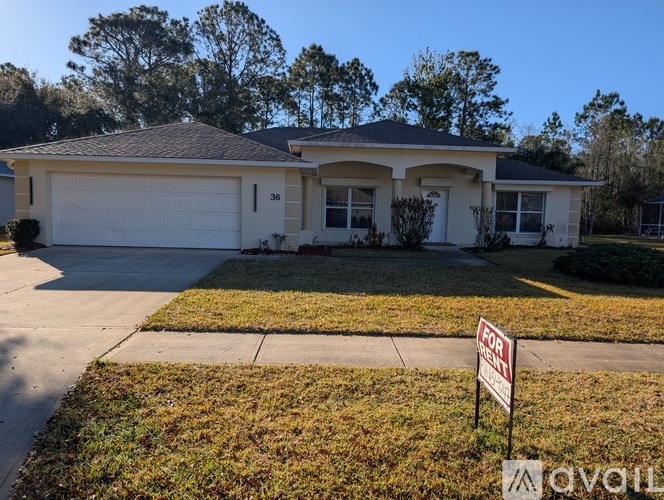 A house with a for sale sign in front of it.