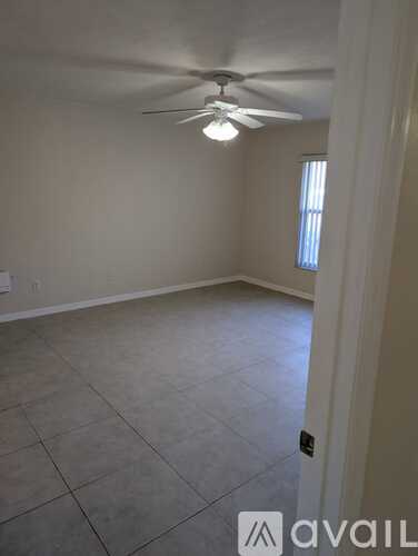 A room with a ceiling fan and tile flooring.