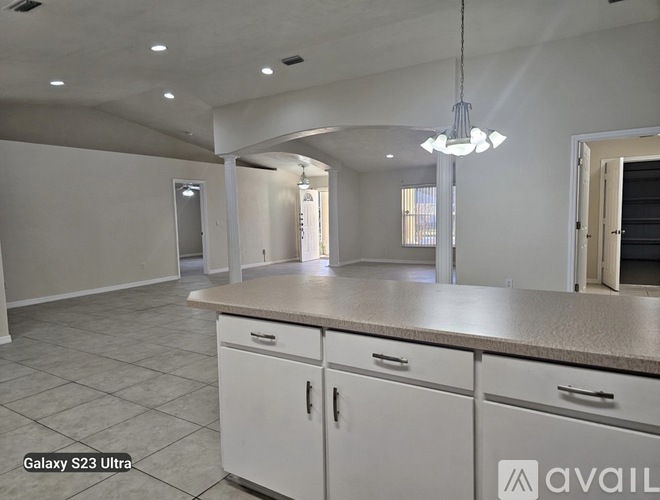 A kitchen with white cabinets and a countertop is available for rent.