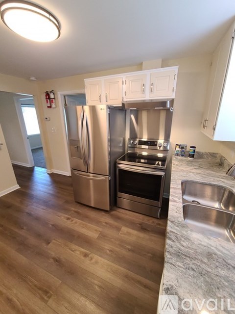 A kitchen with a stainless steel refrigerator, oven, and sink.