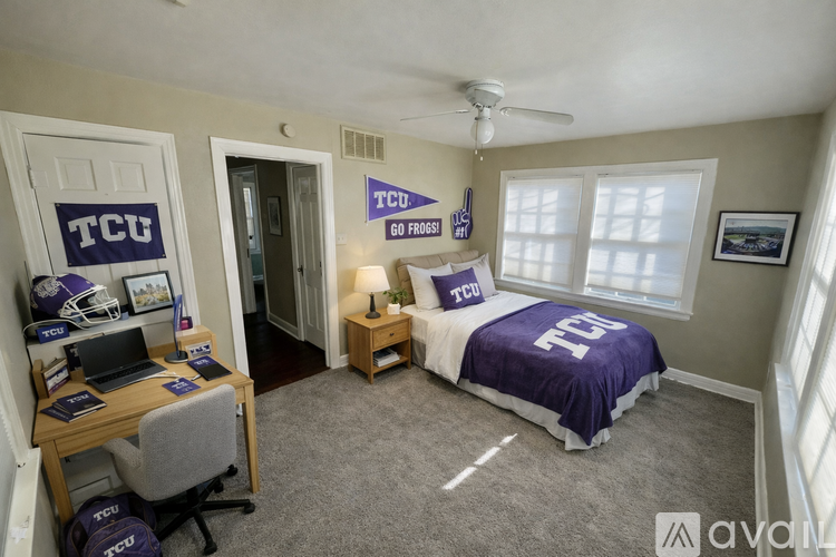 A bedroom with a bed, desk, and TCU decor.