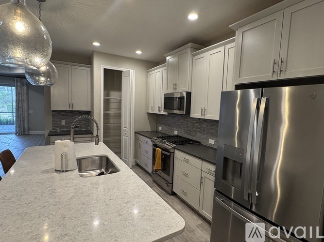 A modern kitchen with a large island and stainless steel appliances.