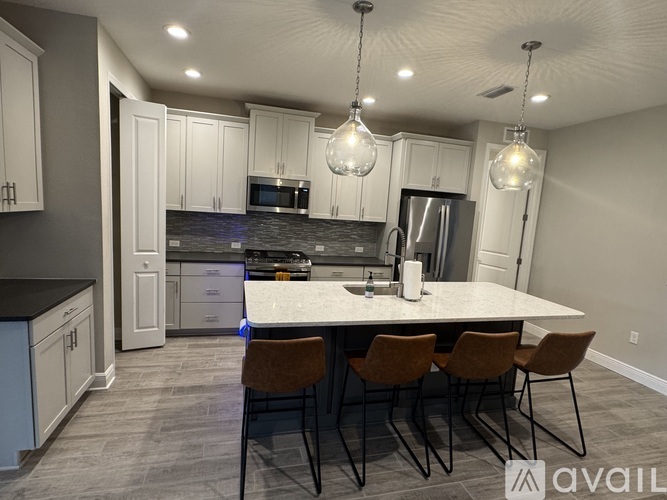 A kitchen with a table and chairs in the foreground and a refrigerator in the background.