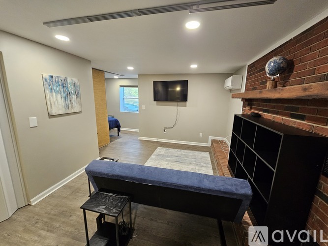 A room with a bed, a chair, and a painting on the wall.
