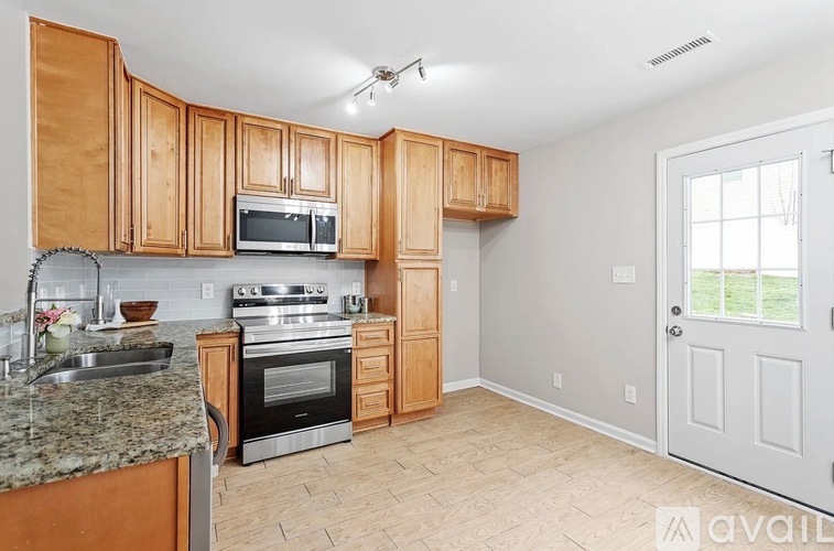 A kitchen with wooden cabinets and a granite countertop.