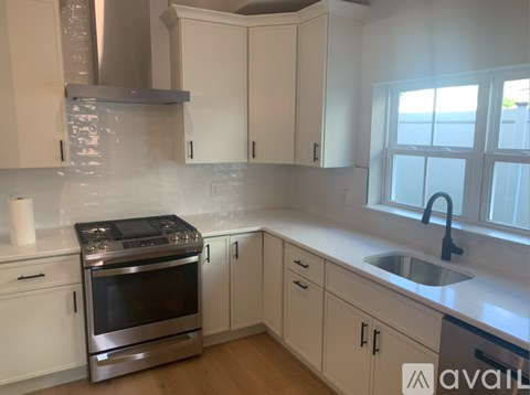 A kitchen with white cabinets and a stainless steel oven.