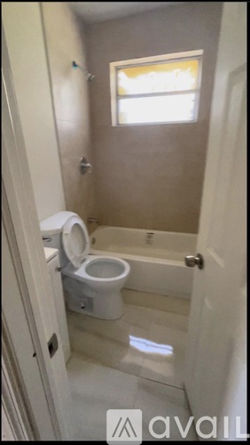A small bathroom with a toilet and a window.