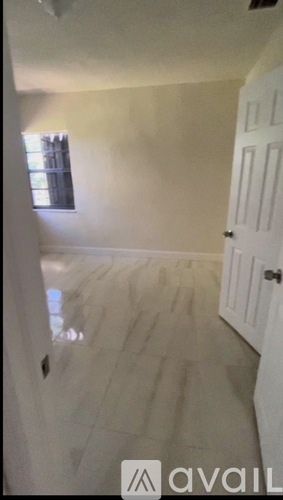 A room with a white door and a window.