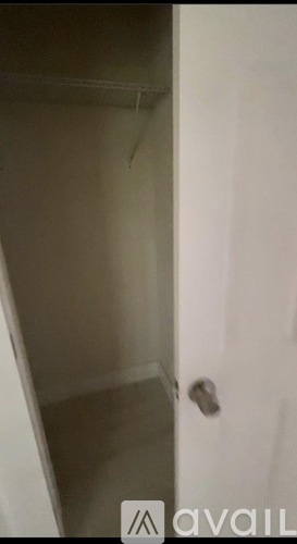 A white door with a silver handle is slightly ajar.