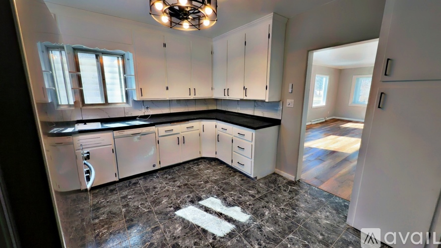A kitchen with a marble floor and a chandelier hanging from the ceiling.