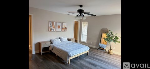 A bedroom with a bed, nightstands, and a ceiling fan.