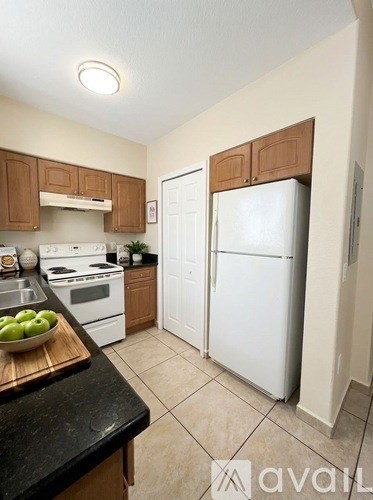 A kitchen with white appliances and wooden cabinets.