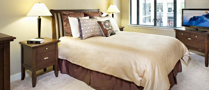 a bedroom with a bed and two lamps and a window