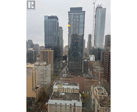 A cityscape with a building that has a yellow arrow on it.
