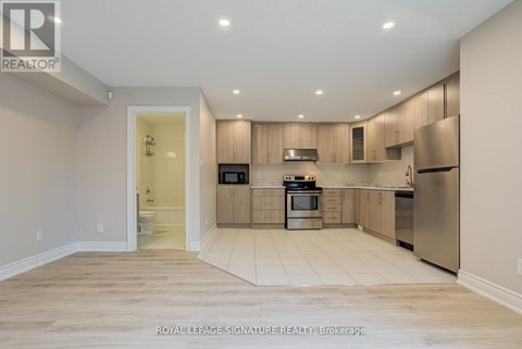 A kitchen with wooden cabinets and stainless steel appliances.