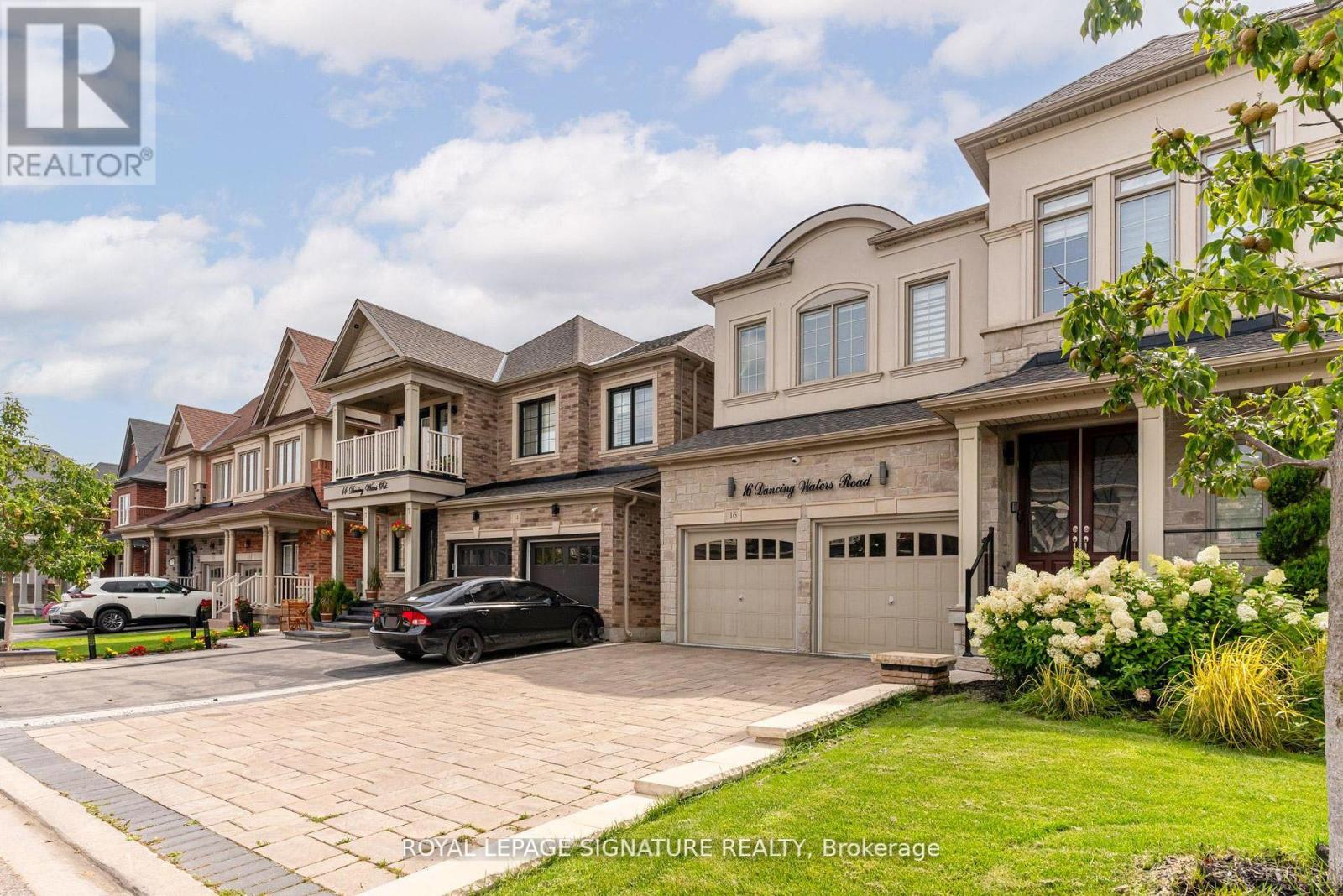 A row of houses with a car parked in front of one.
