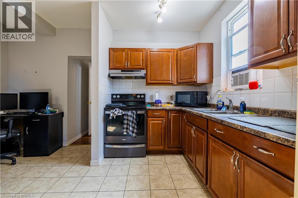 A kitchen with brown cabinets and a black stove top oven.