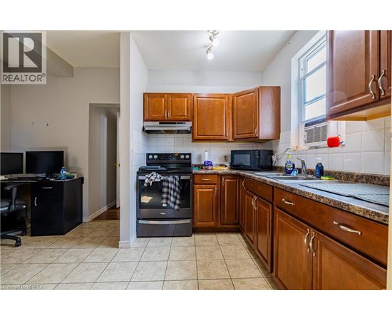 A kitchen with brown cabinets and a black stove top oven.