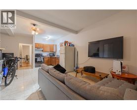 A living room with a grey couch, a television, and a bicycle.