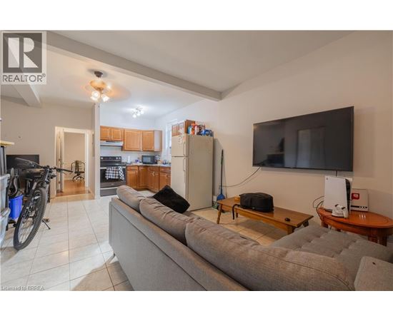 A living room with a grey couch, a television, and a bicycle.
