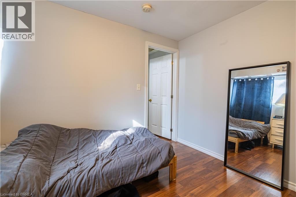 A bedroom with a bed, dresser, and mirror.