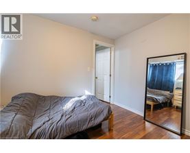 A bedroom with a bed, dresser, and mirror.