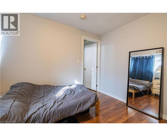 A bedroom with a bed, dresser, and mirror.