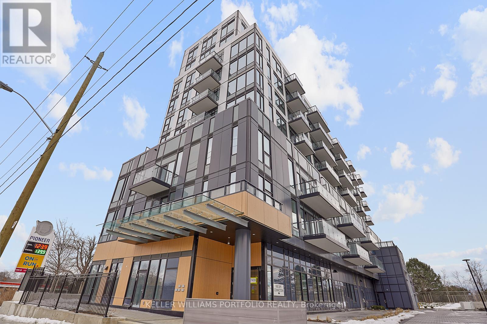 A tall residential building with a glass entrance and a sign that says "REALTOR".