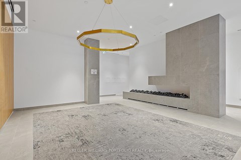 A modern living room with a grey rug and a circular gold chandelier.