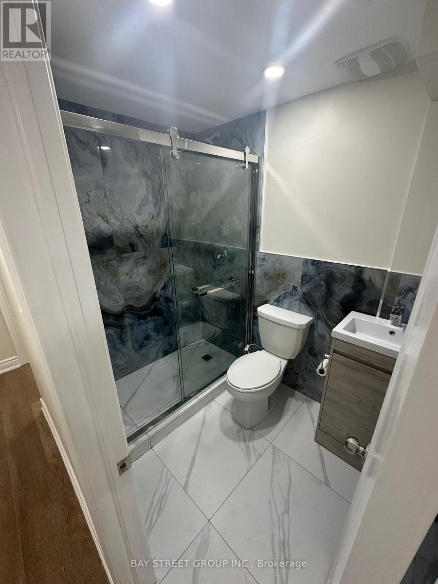 A white toilet in a glass enclosed shower stall.