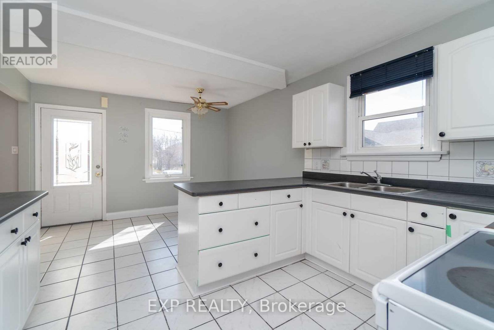 A kitchen with white cabinets and a black countertop.