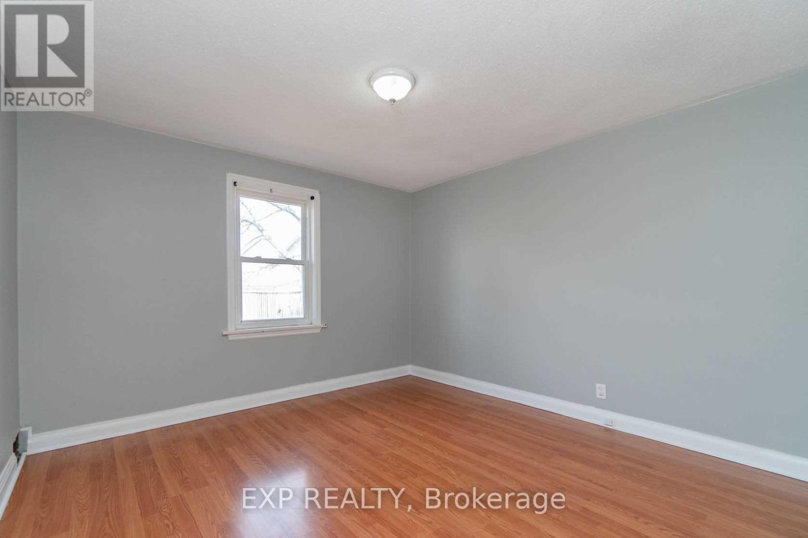 A room with a window and wooden flooring.